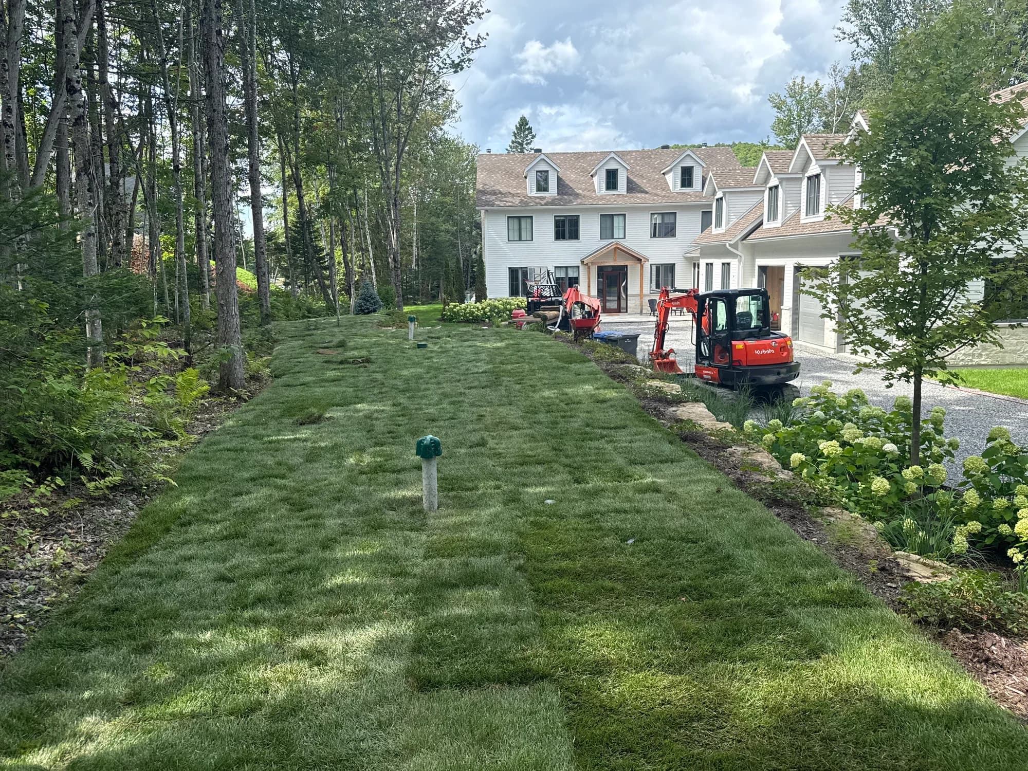 Terrain gazonné devant une résidence avec équipement de chantier